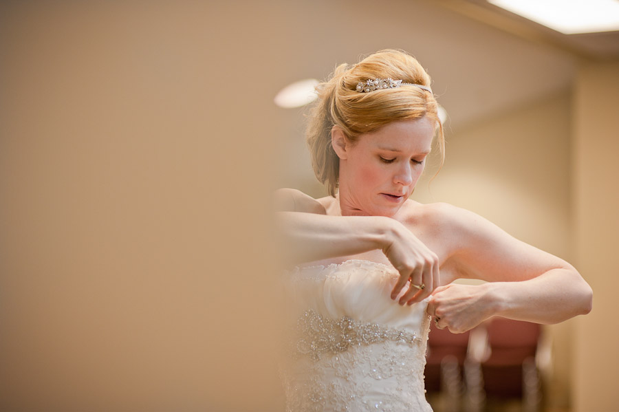 bride fixing dress at church 