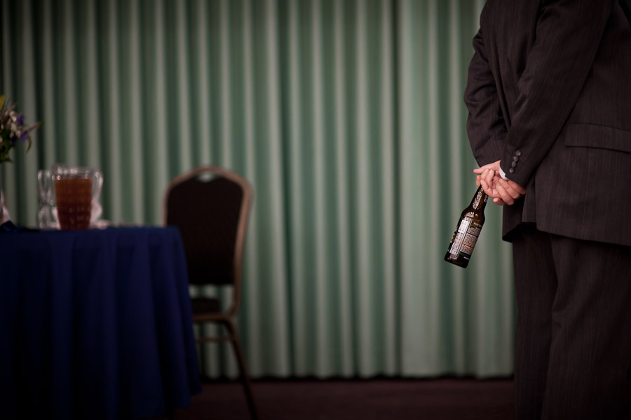 funny moment of man holding beer bottle at wedding