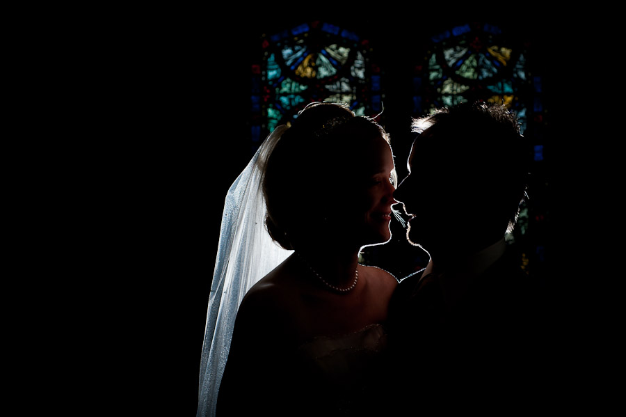 strobist portrait of bride and groom in front of stained glass