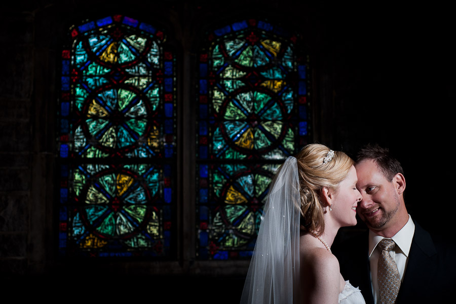 strobist portrait of bride and groom with stained glass