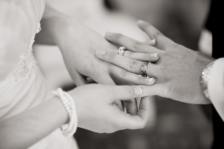 bride and groom looking at wedding rings