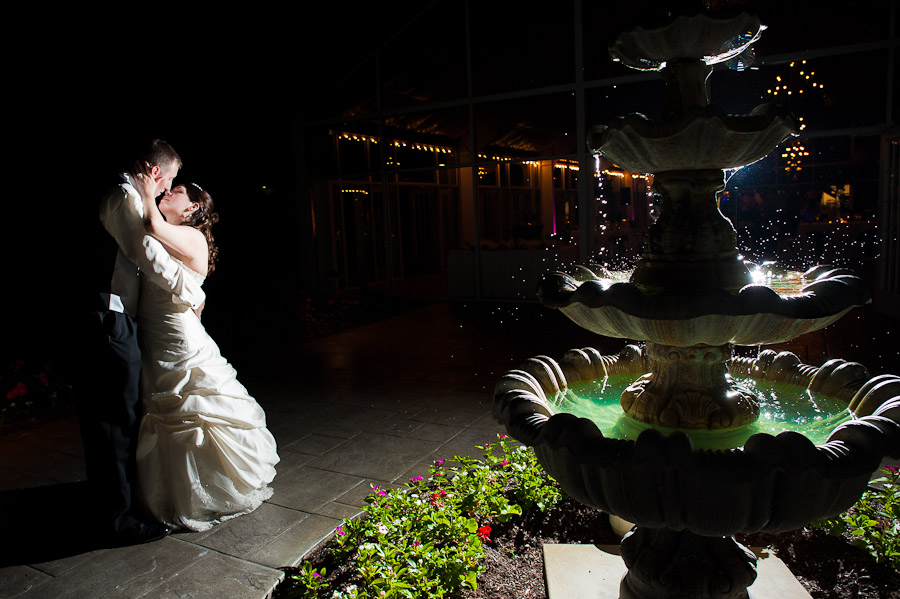 elegant strobist portrait of bride and groom at night next to fountain