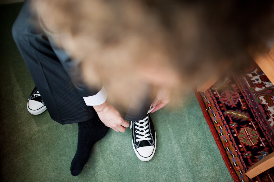 Groom putting on chuck taylor's