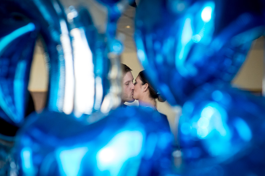 Awesome first kiss shot through blue LOVE balloons