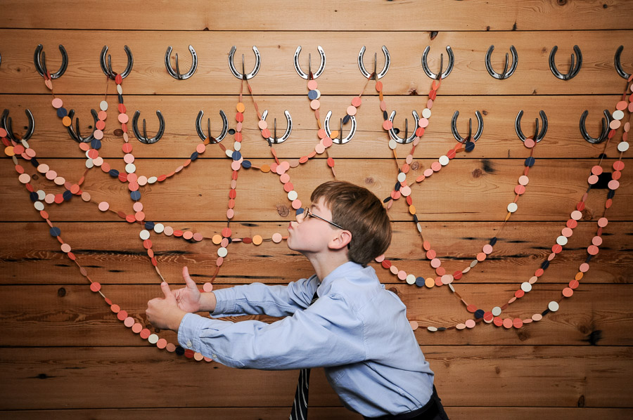 Really hilarious photo of funny kiddo in photobooth with streamers and horseshoes