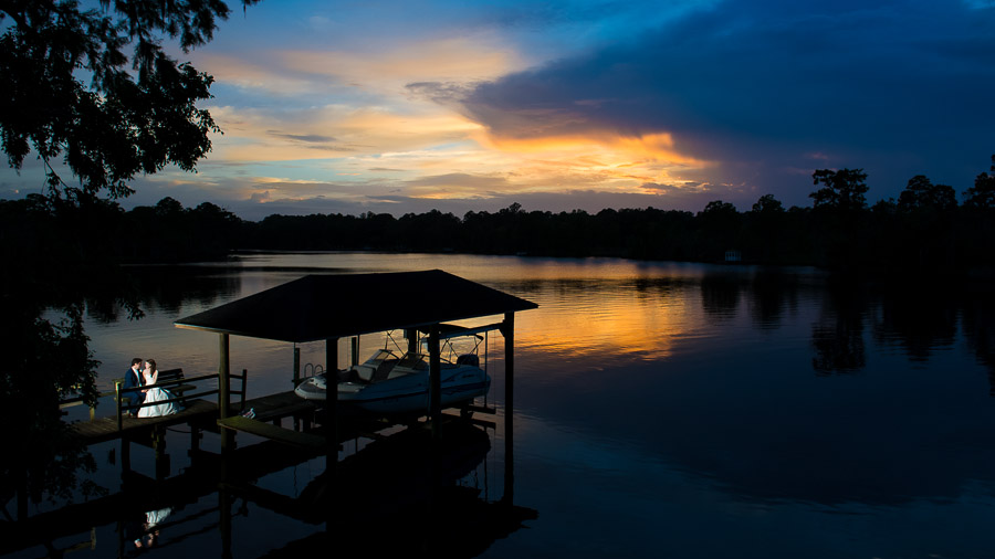 gorgeous breathtaking image of bride and groom on boat dock at sunset