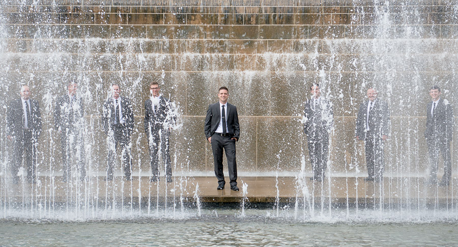 Fun groomsmen portrait behind water