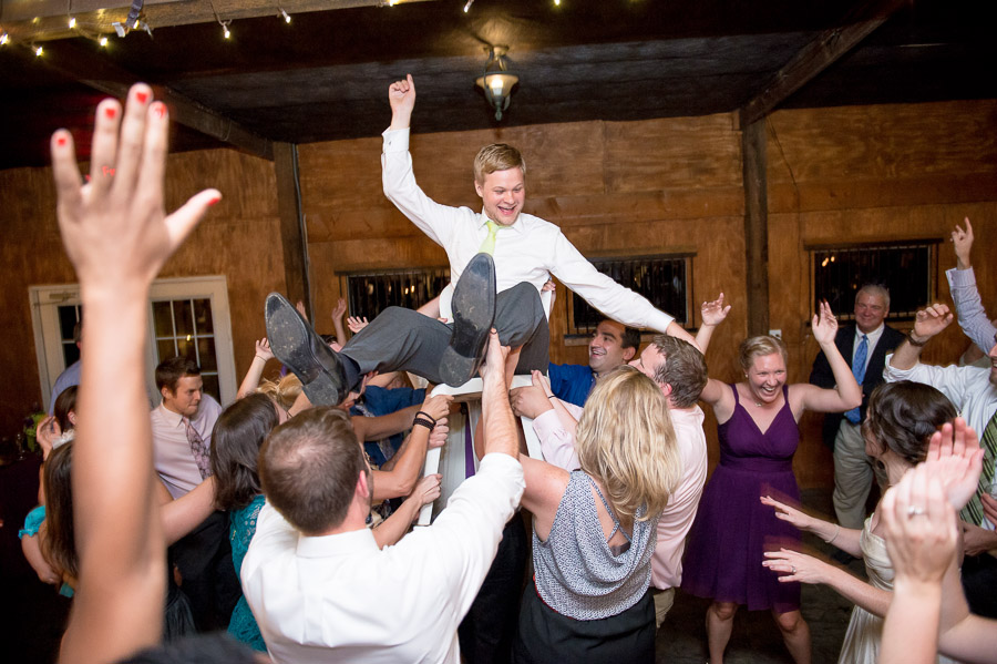 fun, wild, energetic dance floor photo with groom in the air at Bluemont Vineyard wedding