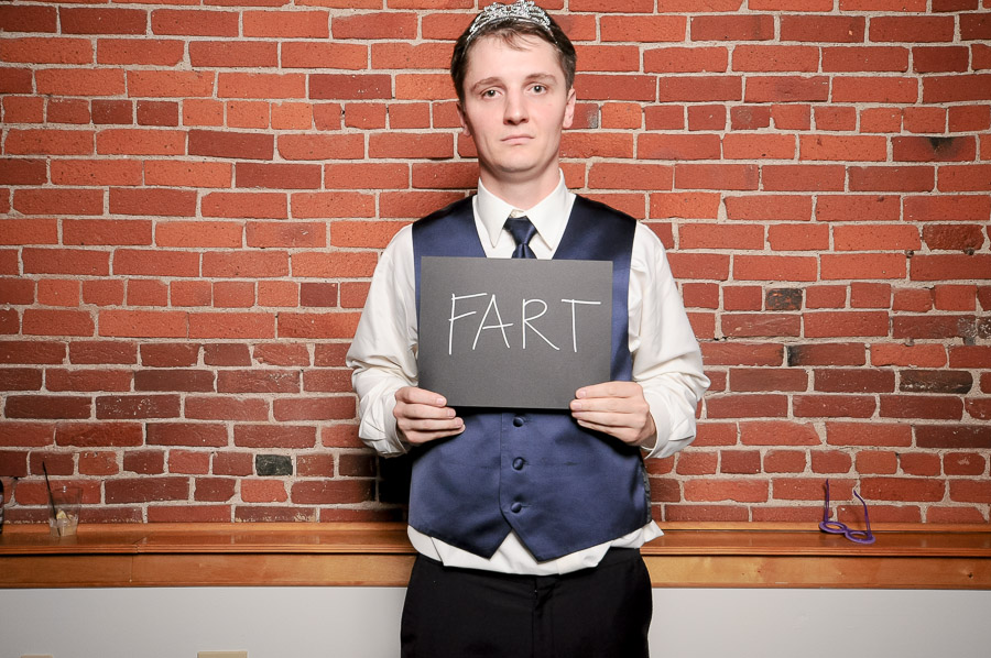 Very silly photobooth pic of dude in tiara with funny chalkboard sign at Indiana wedding