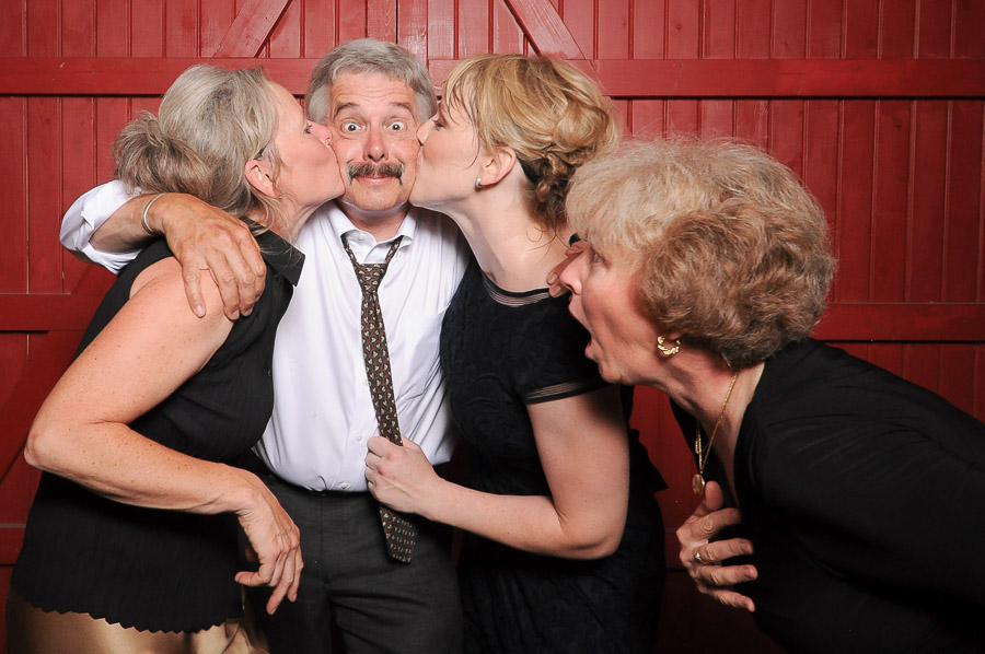 Tall + small Photobooth photo of very happy dude getting kisses at Indiana wedding