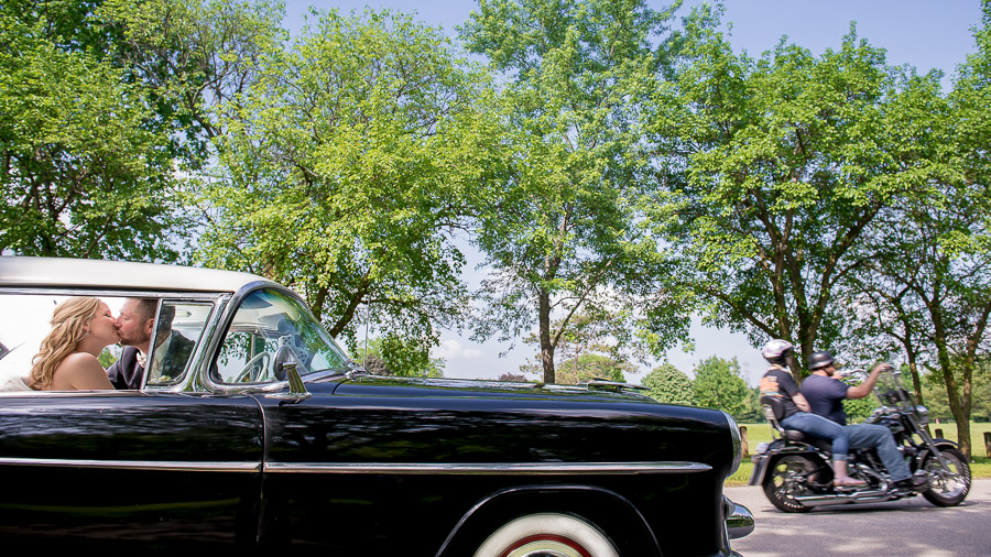 Awesome wedding portrait in classic car with motorcycle photobomb in Indiana