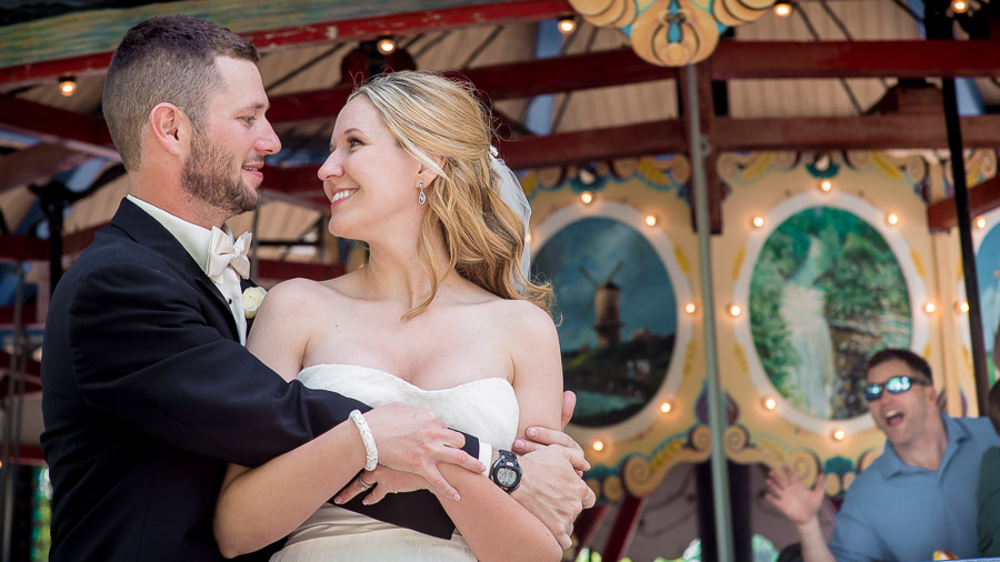 funny photobomb of wedding couple by dude on carousel at Indiana wedding