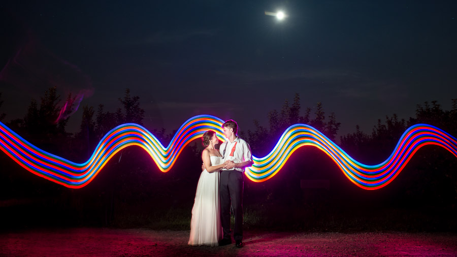 Fun, colorful light painting with bride and groom in orchard by TALL + small Photography