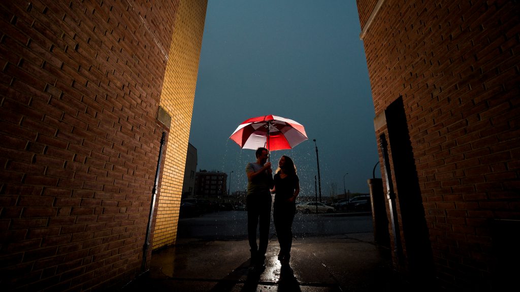 Rachel + Travis under an umbrella during their engagement shoot