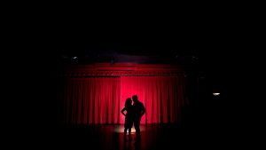 Rachel + Travis spotlit at a theater