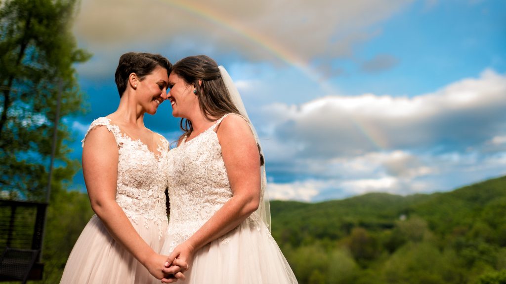 Ashley + Sarah under a rainbow right after there ceremony at their Bold Rock wedding