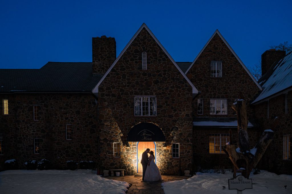 Bride and groom silhouette kissing in front of the door at the Poplar Spring Manor House in Warrenton, VA