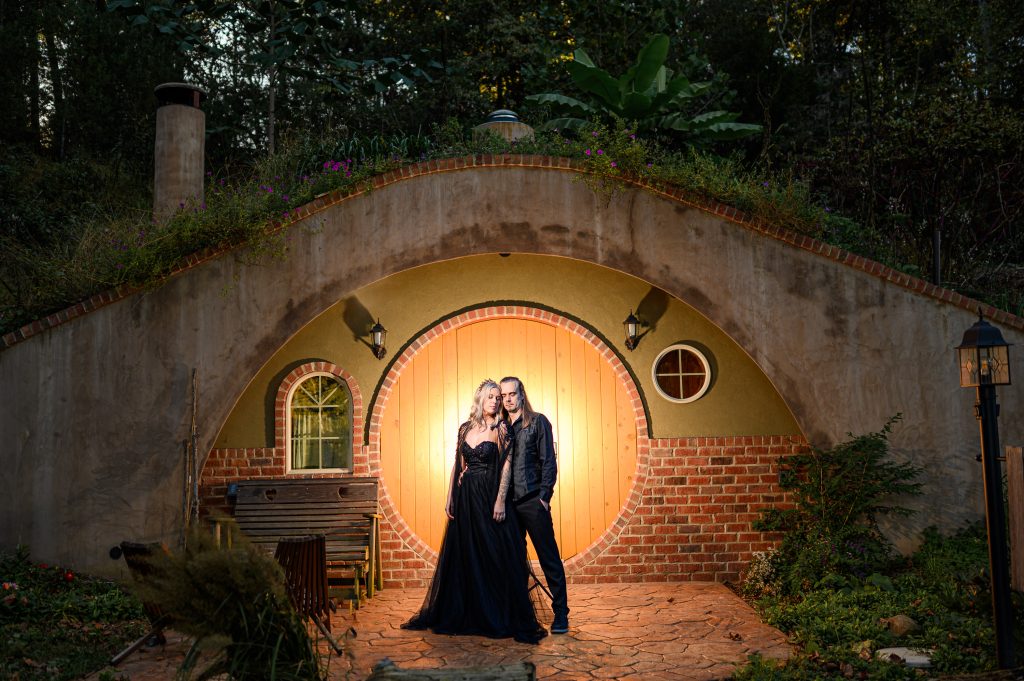 Backlit portrait of couple at their vow renewal wedding photos in front of a Hobbit House