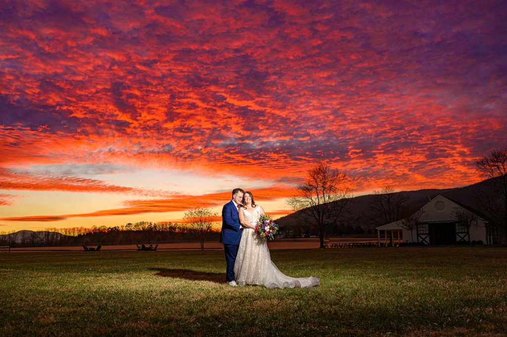 Couple standing in the field at King Family Vineyards at their Crozet wedding photography in front of a magical sunset