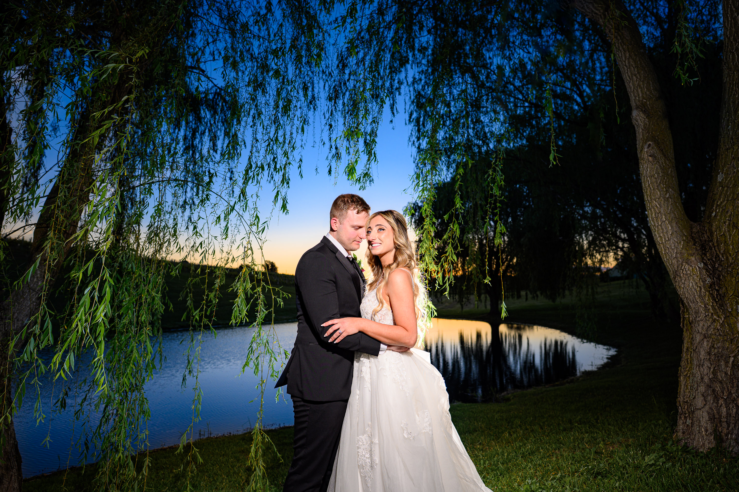 Couple in front of pond at night at CrossKeys Vineyards wedding.