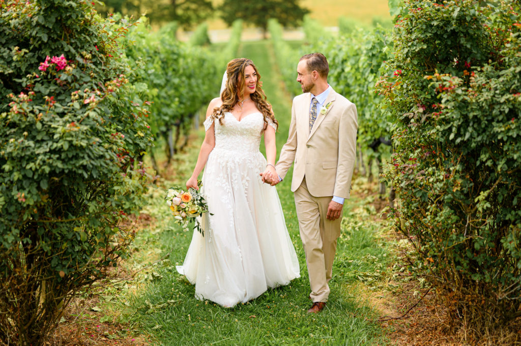 Couple walking through vineyard during their central virginia wedding photography