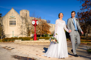 couple walking in front of the iconic red clocks at their imu tudor room wedding