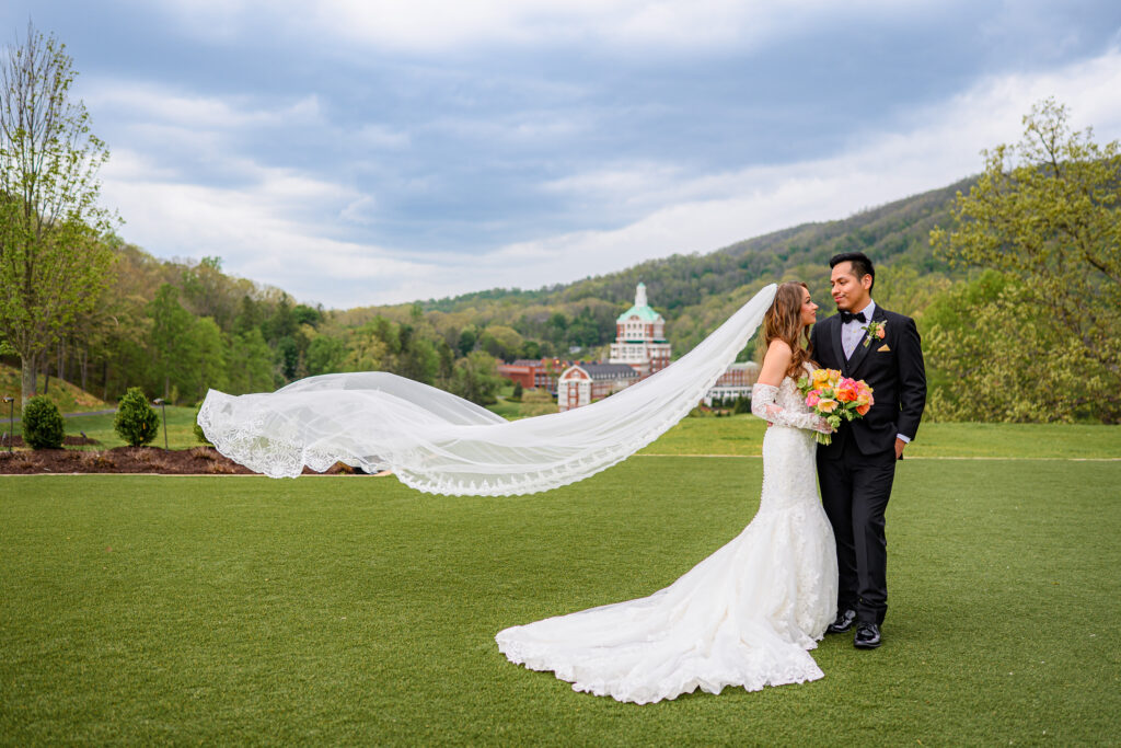 Couple with veil blowing in wind at their Omni Homestead Wedding Photography