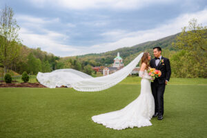 Couple with veil blowing in wind at their Omni Homestead Wedding Photography